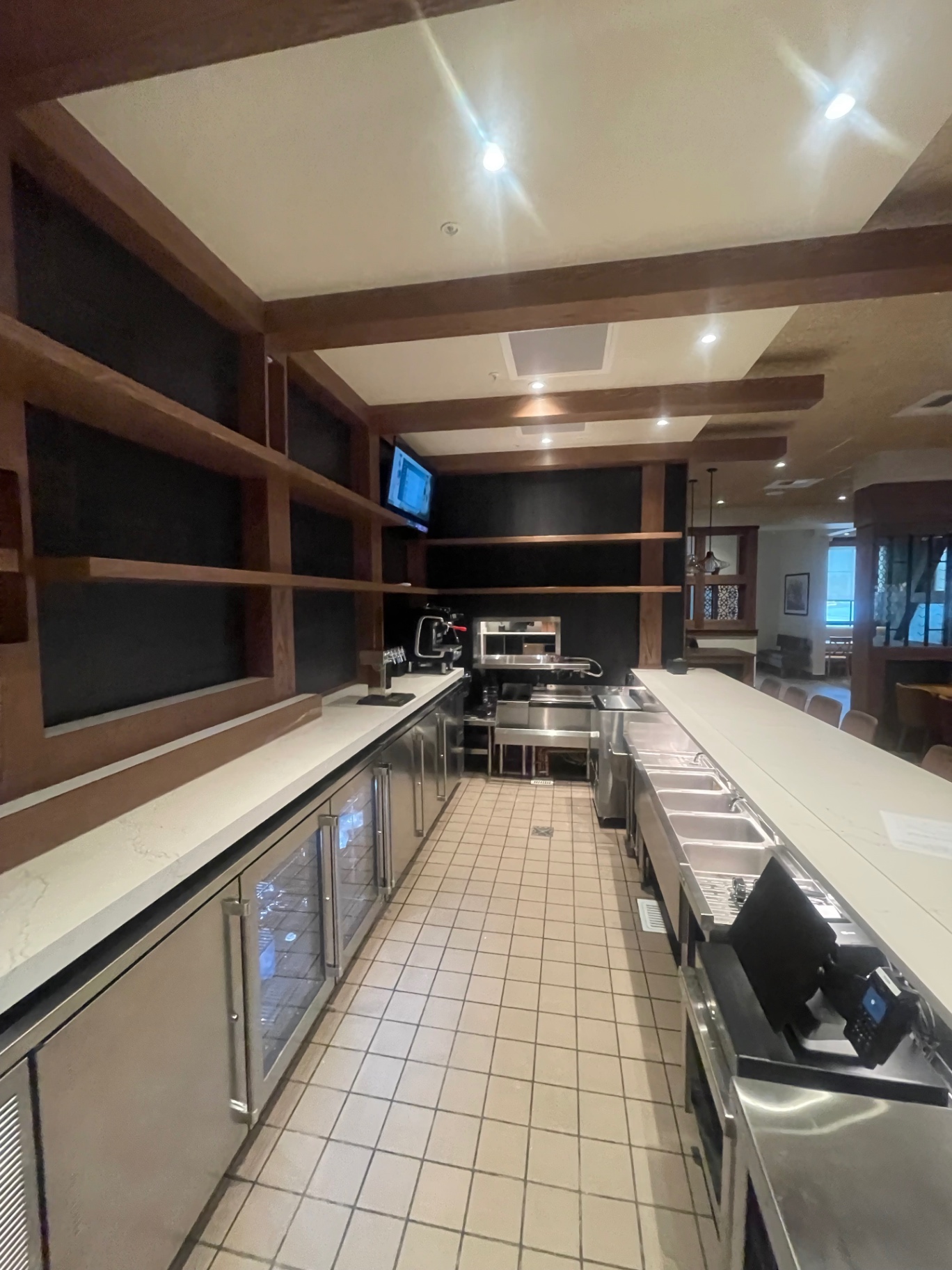 Service aisle behind the bar with cleaned tile floor and stainless equipment