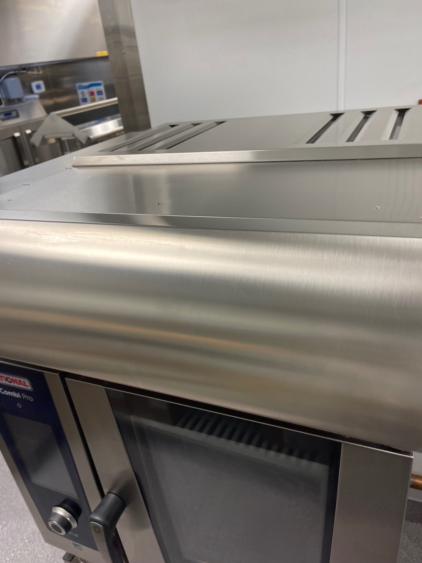 Detail of a cleaned stainless-steel combi oven surface in the commercial kitchen