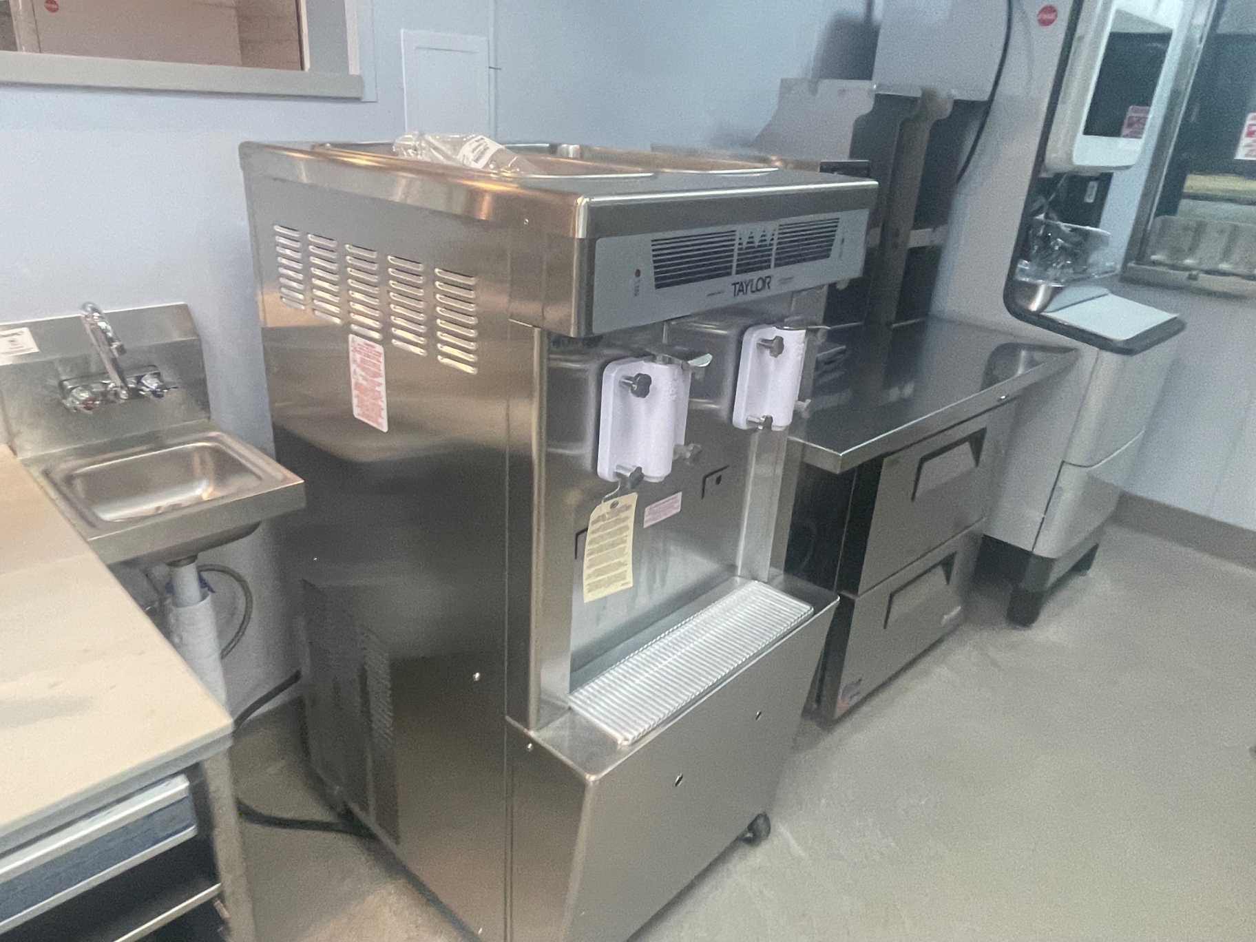 Cleaned soft-serve machine and stainless hand sink in the foodservice area