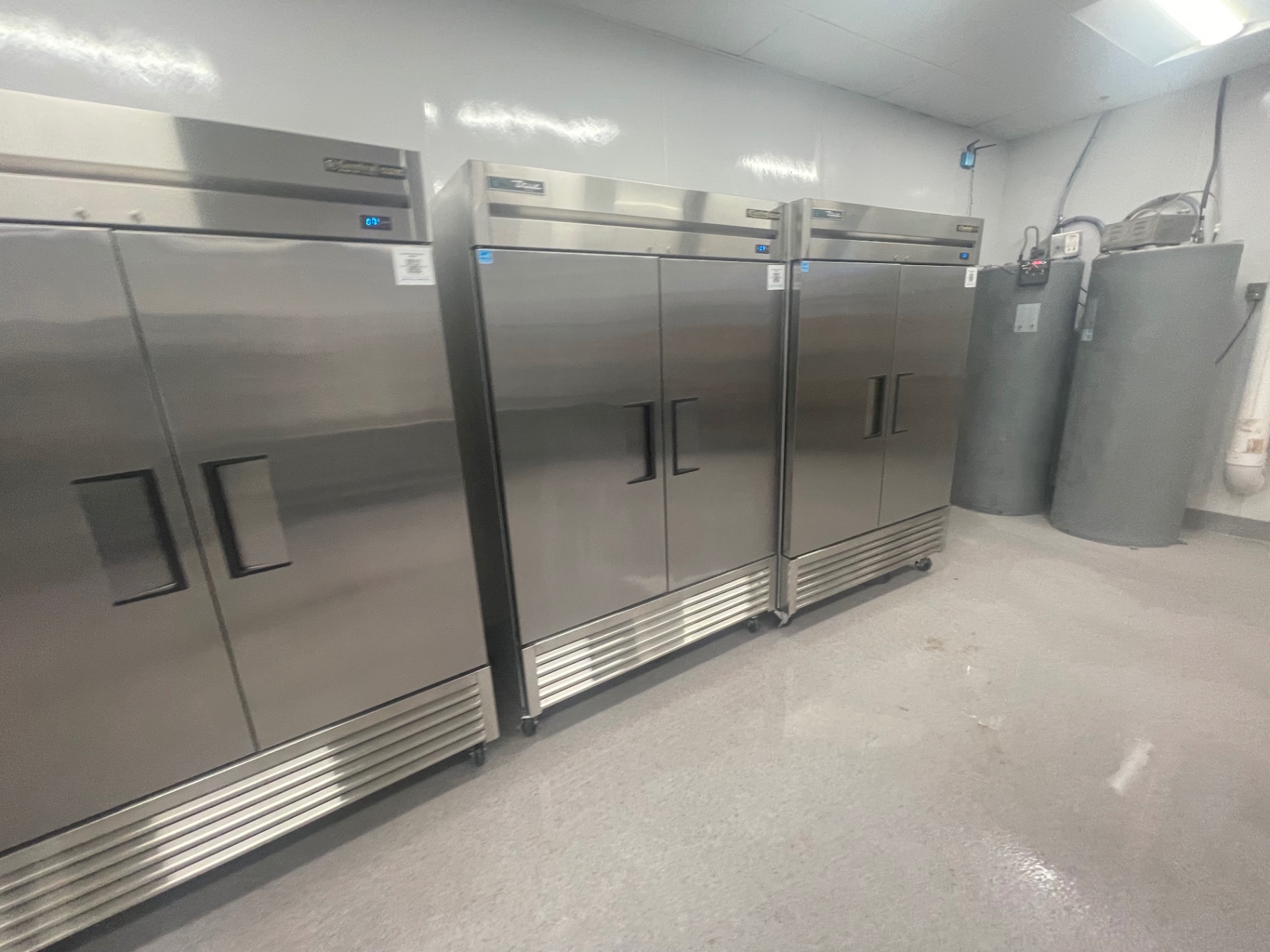 Stainless refrigeration units and water heater in the back-of-house area