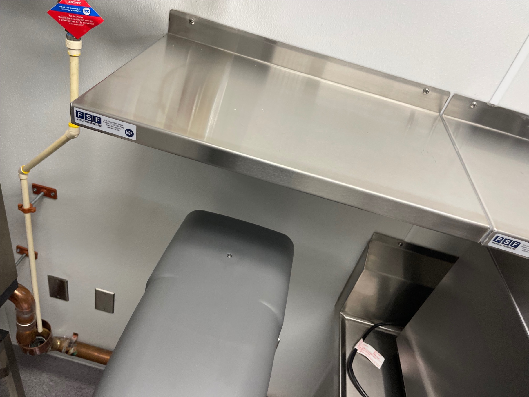 Cleaned stainless-steel wall shelf above a kitchen work area