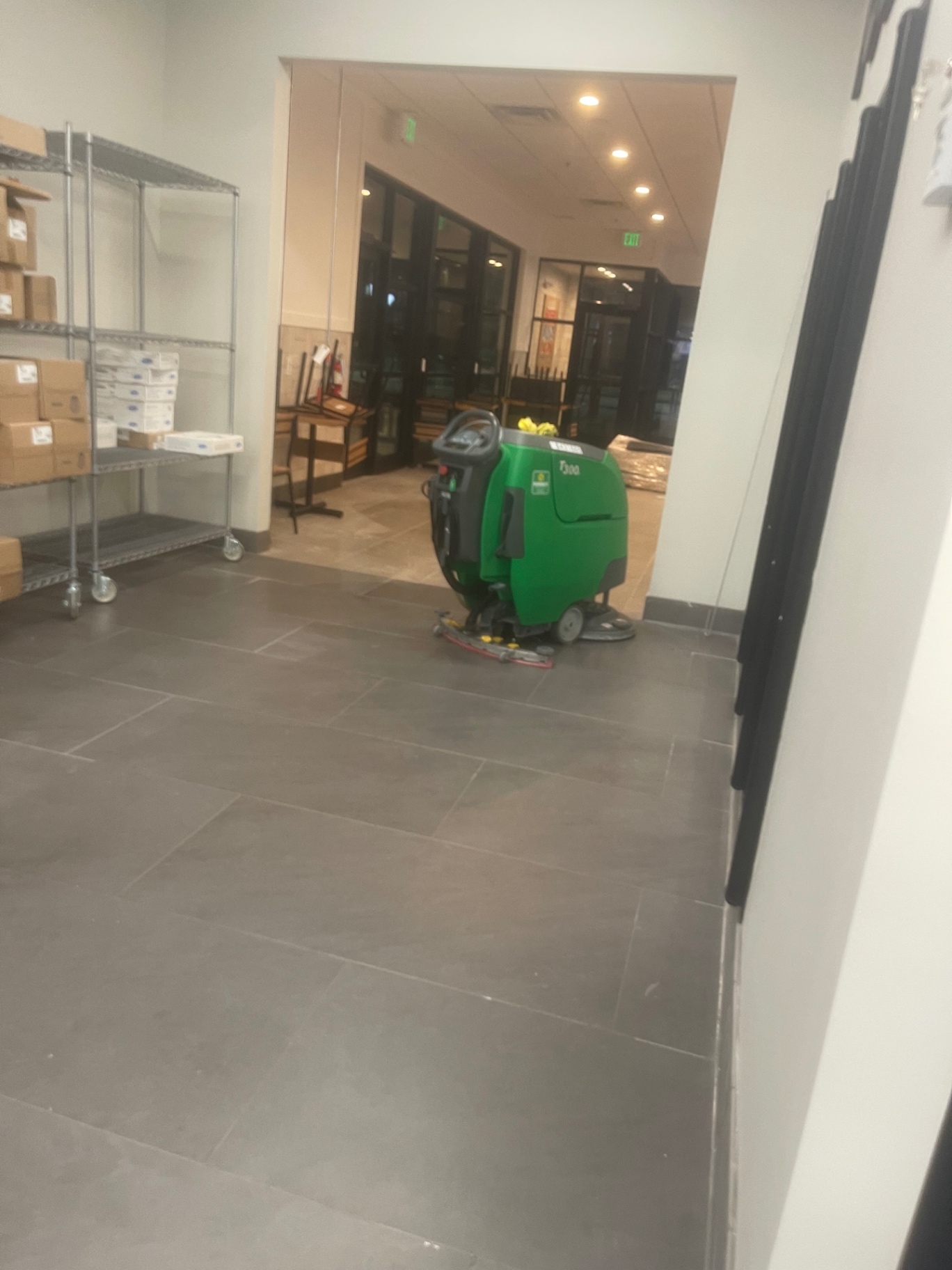 Walk-behind floor scrubber in use on the retail tile floor